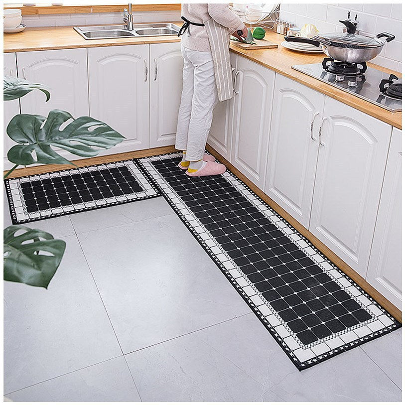 Woman standing on black and white mosaic coloured kitchen rug.