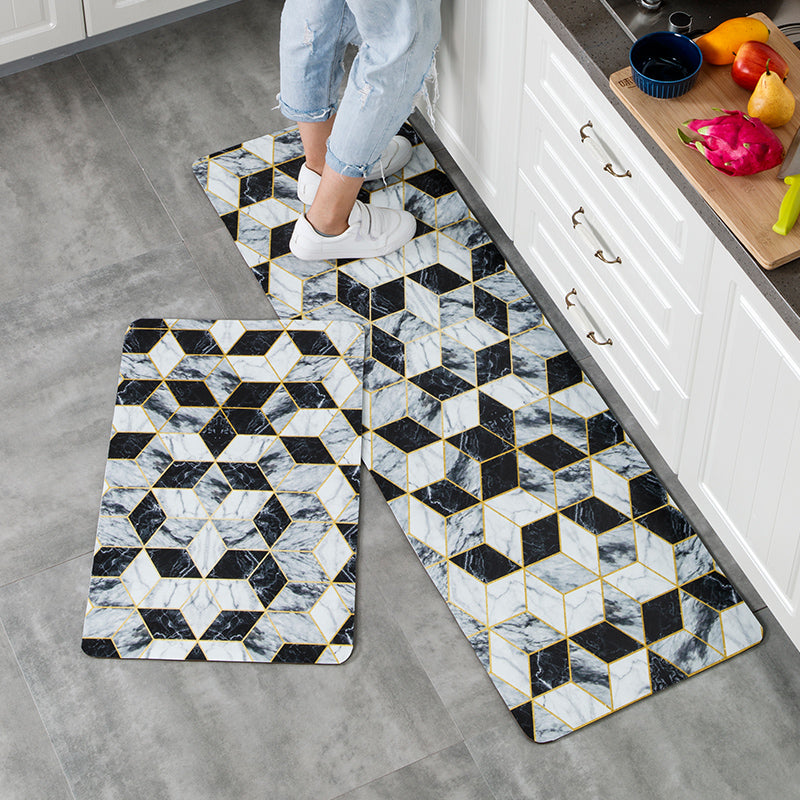 Woman standing on Anti Fatigue Kitchen Mats set printed with different marble colours in diamond pattern.