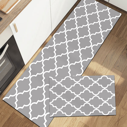 Rectangular rug with geometric pattern in gray and white on wood floor