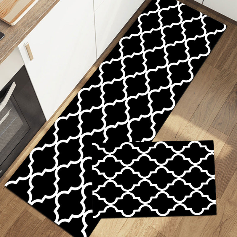 Rectangular rug with geometric pattern in black and white on wood floor