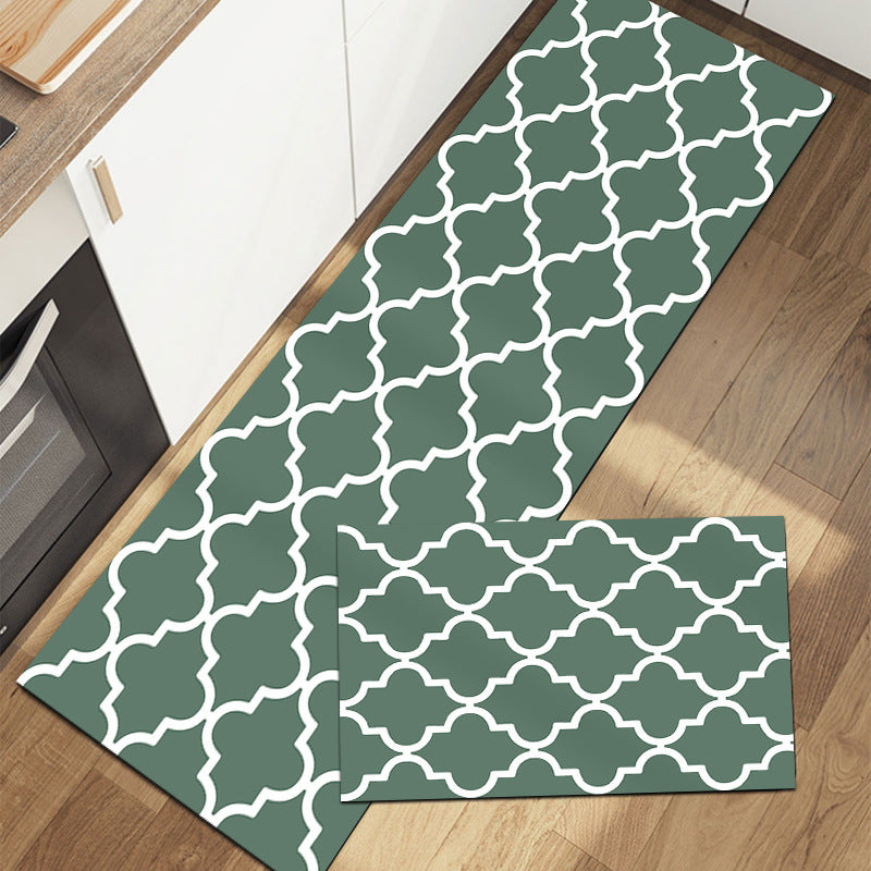 Rectangular rug with geometric pattern in gray green and white on wood floor