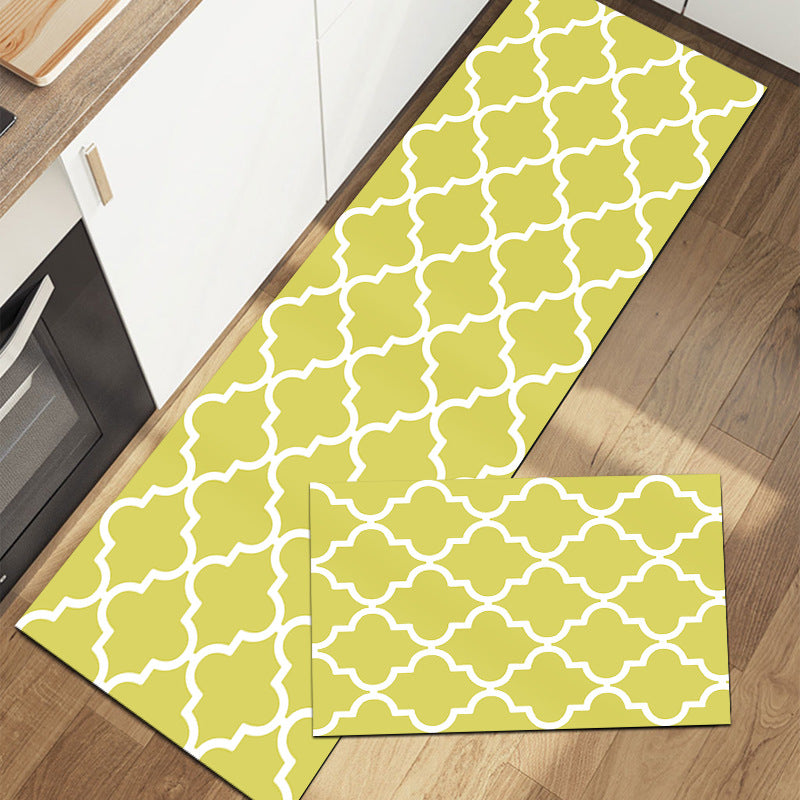 Rectangular rug with geometric pattern in yellow and white on wood floor