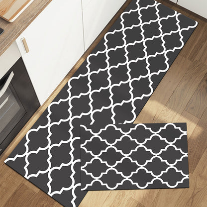 Rectangular rug with geometric pattern in dark gray and white on wood floor