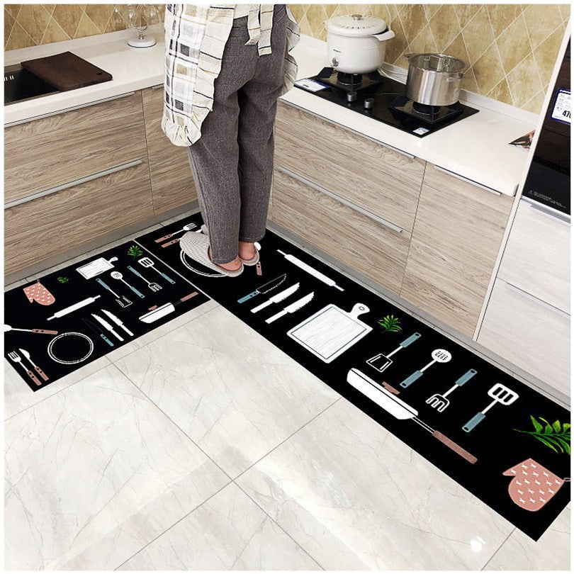 Woman standing on black coloured kitchen rug printed with Jane Eyre tableware.